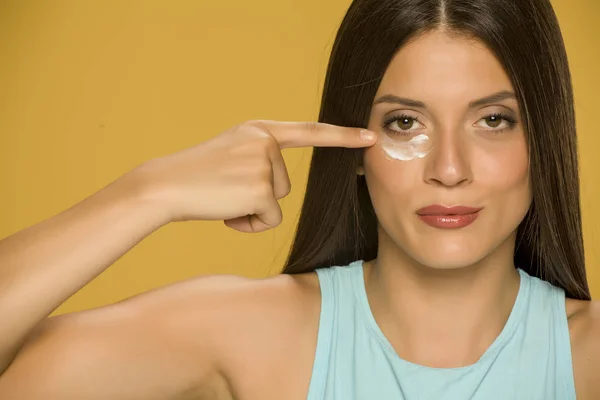 Wanita Muda Yang Mengoleskan Kreme Kelopak Matanya Yang Rendah Dengan — Stok Foto