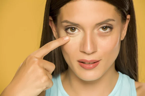 Jeune Femme Touchant Ses Paupières Basses Sur Fond Jaune — Photo