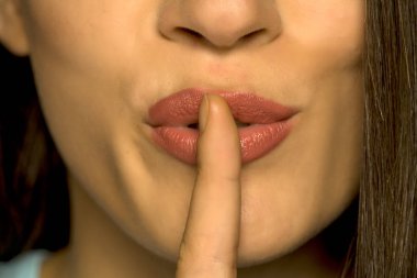 Dudaklarında parmağı olan kadının yakın çekim