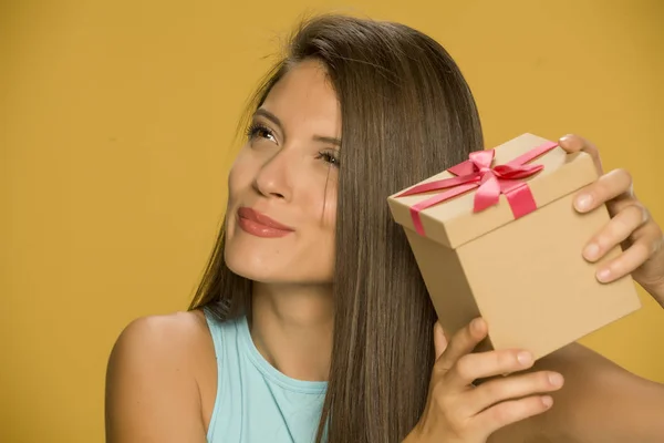 Young Beautiful Curious Woman Holding Present Box Yellow Background — Stock Photo, Image