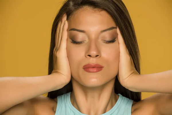 Young Woman Tightens Her Face Her Hands Yellow Background — Stock Photo, Image