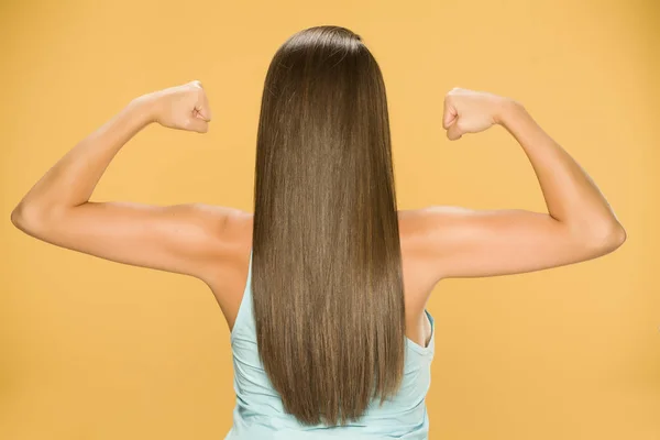 Widok Tyłu Młodej Kobiety Długimi Włosami Pokazując Jej Ręce Żółtym — Zdjęcie stockowe