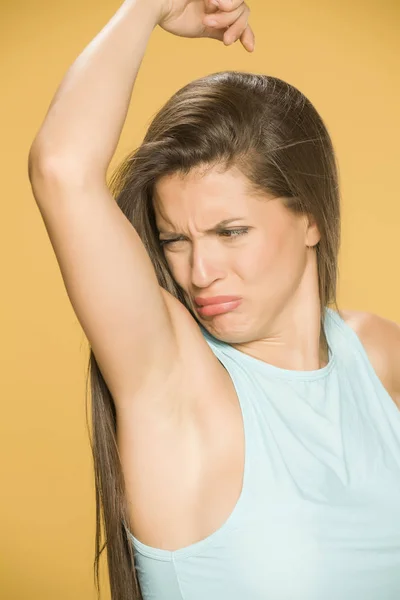 Young Woman Smells Her Armpit Yellow Background — Stock Photo, Image