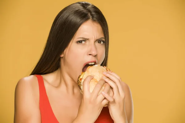 Mladá Chamtivá Žena Která Jedla Burger Žlutém Pozadí — Stock fotografie