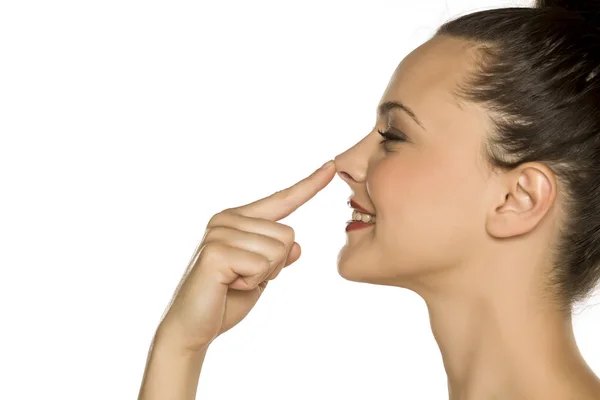 Profil Młodej Szczęśliwej Kobiety Dotyka Jej Nosa Palcem Białym Tle — Zdjęcie stockowe