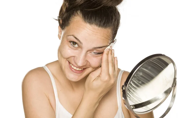 Νεαρή Ευτυχισμένη Γυναίκα Καθαρίζει Πρόσωπό Της Βαμβακερό Pad Λευκό Φόντο — Φωτογραφία Αρχείου