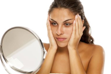 Genç kız elleriyle yüzünü sıkıyor.