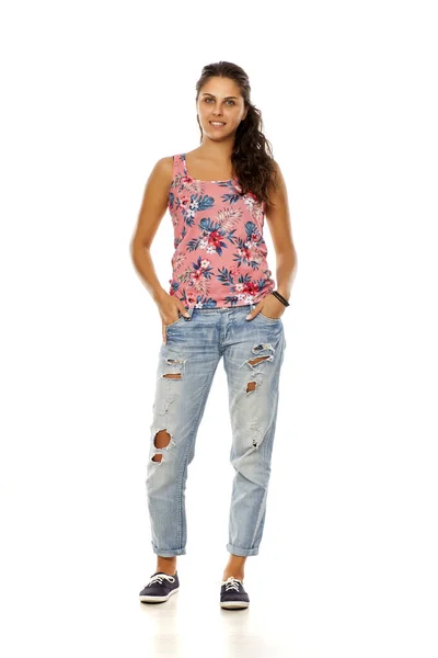 Junge Frau Mit Zerrissenen Jeans Steht Auf Weißem Hintergrund — Stockfoto