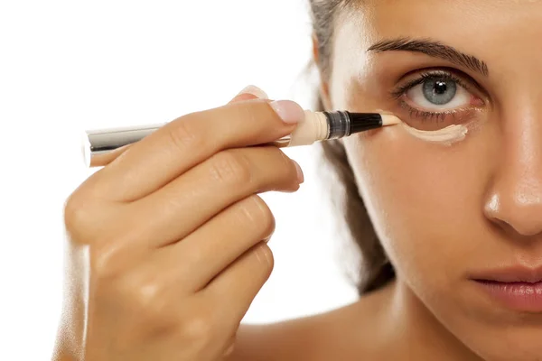 Una Mujer Joven Aplica Corrector Debajo Los Ojos — Foto de Stock