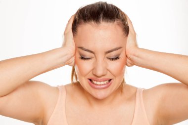 Beyaz arka planda baş ağrısı olan güzel bir kadının portresi.