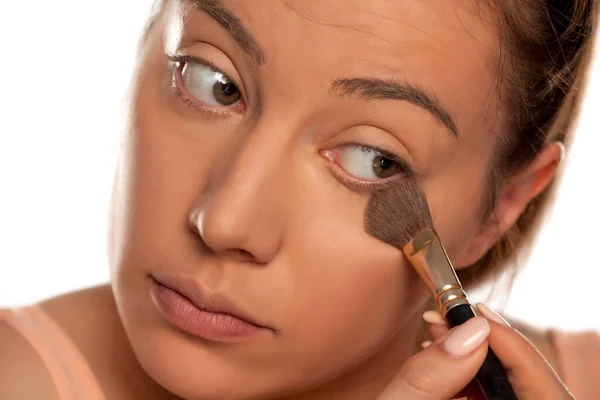 Mujer Joven Aplicando Base Polvo Con Pincel Sobre Fondo Blanco — Foto de Stock