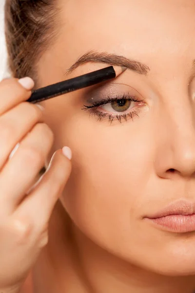 Mujer Joven Contorneando Sus Cejas Con Lápiz Sobre Fondo Blanco —  Fotos de Stock