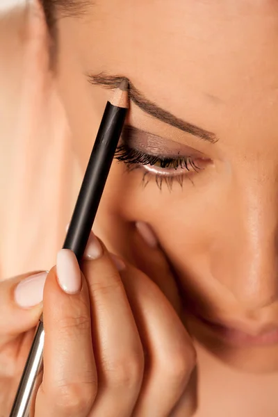 Mujer Joven Contorneando Sus Cejas Con Lápiz Sobre Fondo Blanco — Foto de Stock