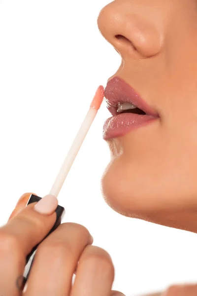 Junge Frau Trägt Lipgloss Auf Weißem Hintergrund Auf — Stockfoto