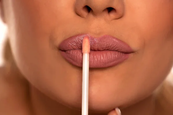 Mujer Joven Aplicando Brillo Labios Sobre Fondo Blanco — Foto de Stock