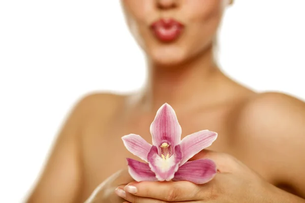 Hermosa Joven Mujer Sostener Una Orquídea Sobre Fondo Blanco — Foto de Stock