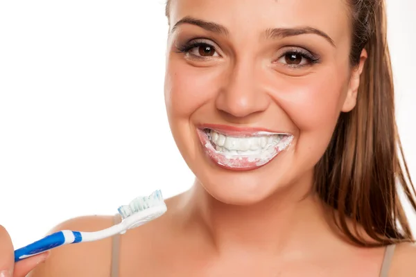 Νεαρή Ευτυχισμένη Γυναίκα Βουρτσίζει Δόντια Της Λευκό Φόντο — Φωτογραφία Αρχείου