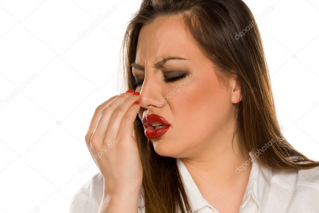 Portrait of beautiful woman checking her breath on white background