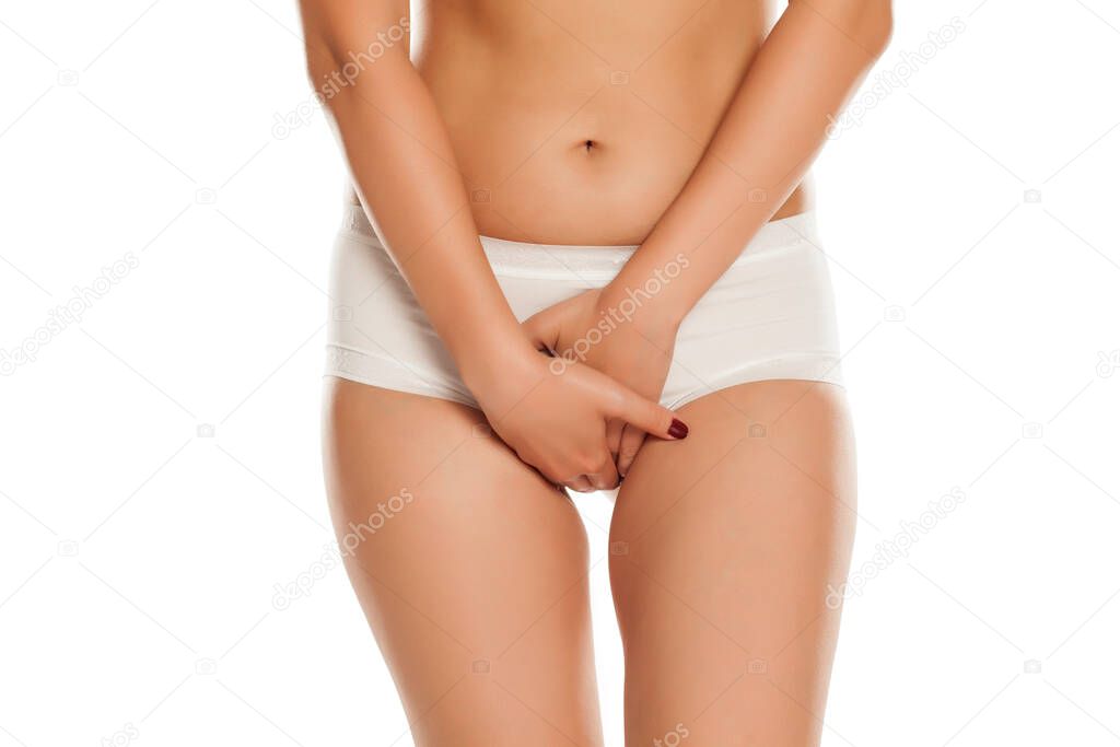 young woman in white panties holding her hands on her crotch