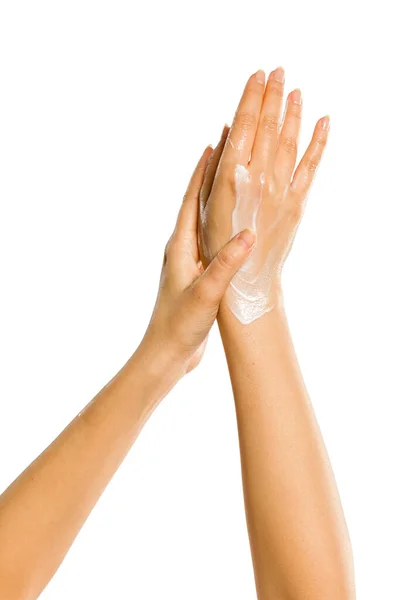白い背景にハンドクリームを塗る女性の手のクローズアップ — ストック写真