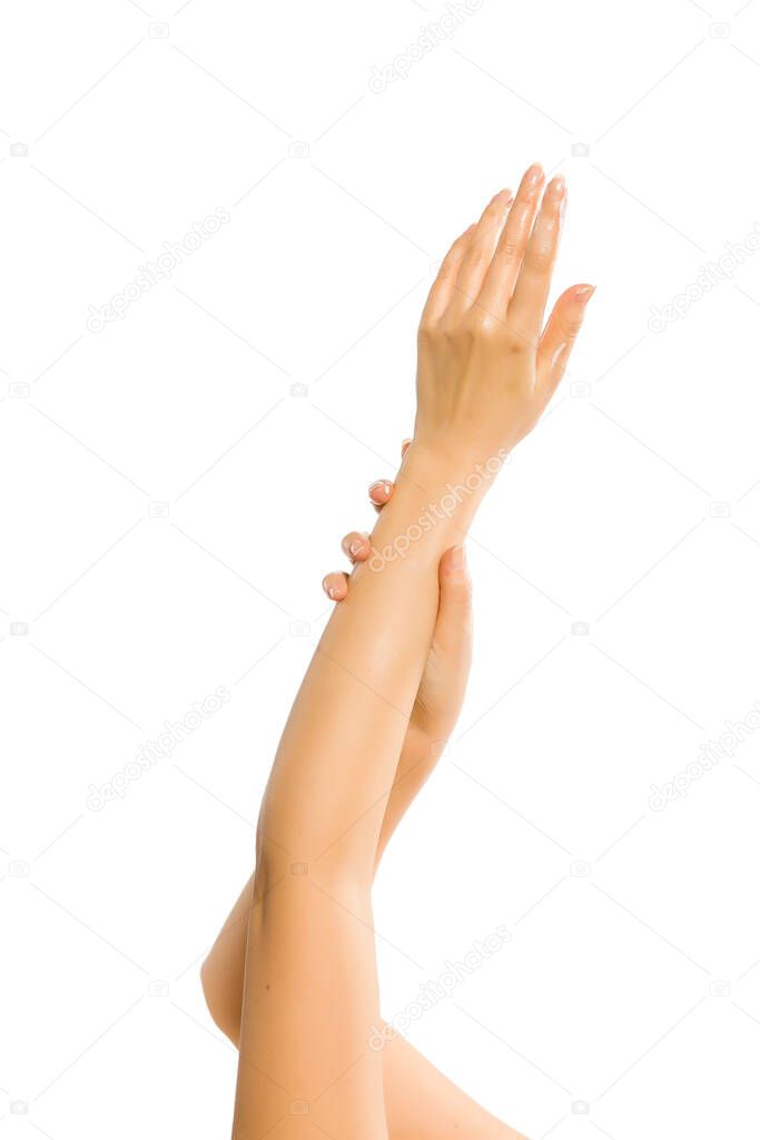 closeup of female hands applying hand cream on white background