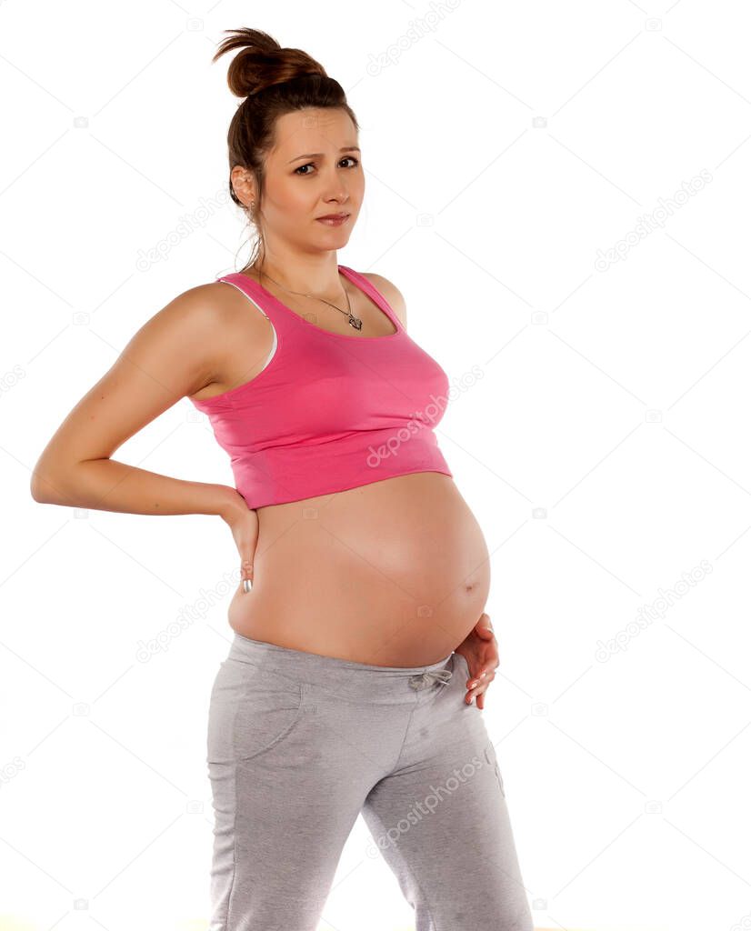 tired pregnant woman posing on a white background