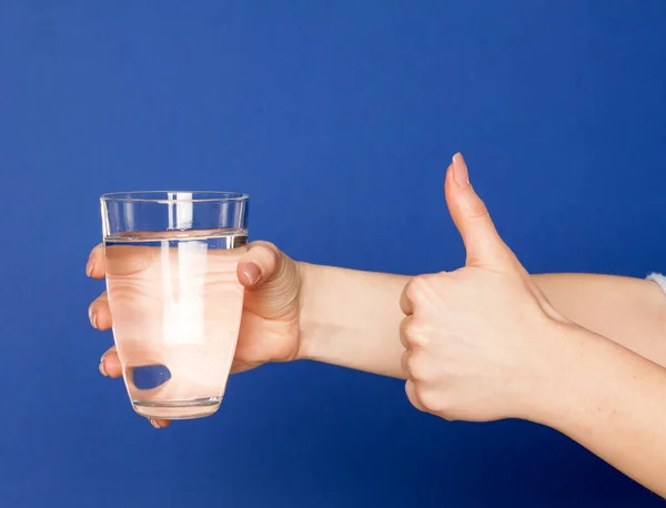 Mão Feminina Segurando Copo Água Fundo Azul Mostrando Polegares Para — Fotografia de Stock