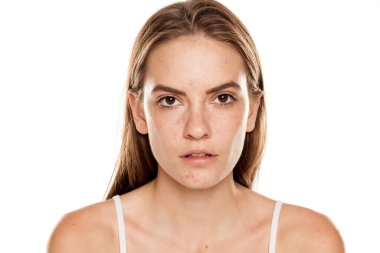 Beyaz arka planda makyajı olmayan güzel bir kadının portresi.