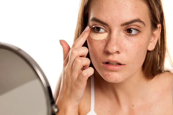 Young Beautiful Girl Applying Concealer Fingers Her Eyes White Backgeound — Stock Photo, Image