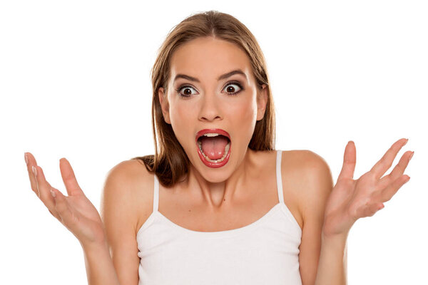 Красивая шокированная девушка на белом фоне
