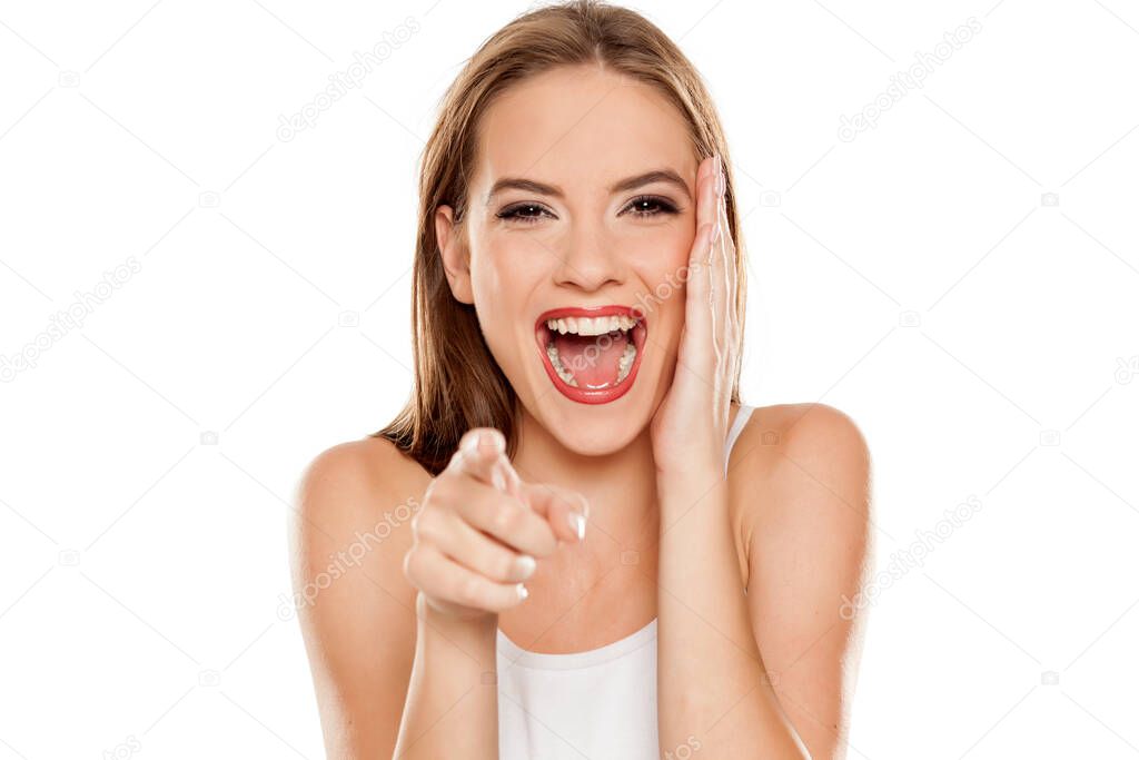 beautiful laughing girl on white background pointing on you