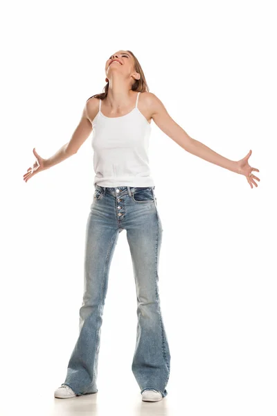 幸せな若いです可愛いです女性Posingでベルボトムジーンズ上の白い背景 — ストック写真