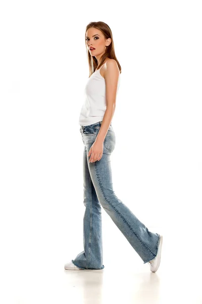 Jovem Mulher Bonita Andando Fundo Sino Jeans Fundo Branco — Fotografia de Stock