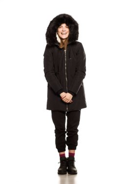 Beyaz arka planda poz veren kışlık ceketli genç model.