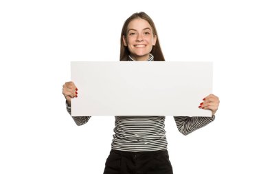 Bluzlu genç model beyaz arka planda boş bir reklam panosu gösteriyor.