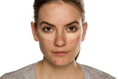 Beyaz arka planda kapatıcıyla poz veren genç bir kadın