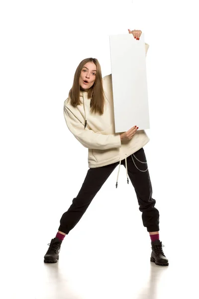年轻快乐的连帽衫模特拿着一块白色背景的空广告牌 — 图库照片