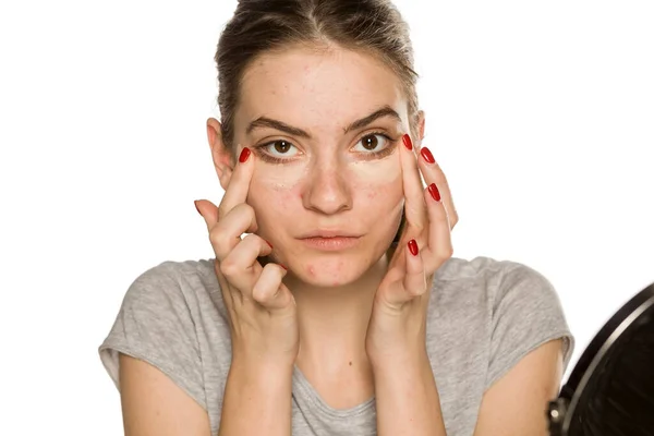 Ung Kvinna Tillämpa Concealer Med Fingrarna Vit Bakgrund — Stockfoto