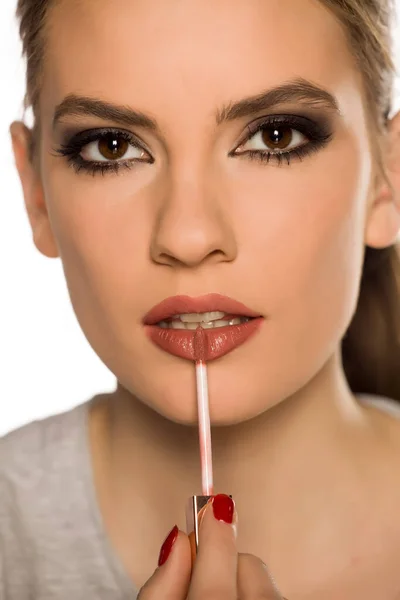 Young Woman Applying Lip Gloss White Background — Stock Photo, Image