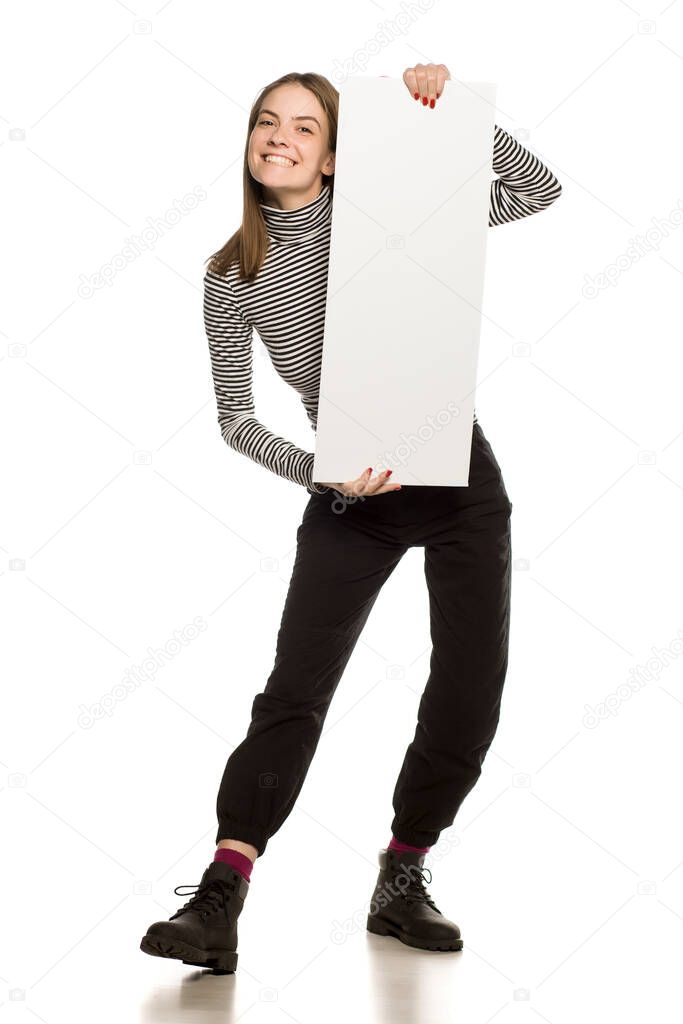 Young model in blouse shows an empty advertising board on white background