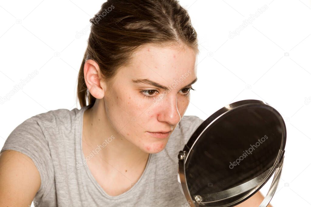 Young concerned woman without makeup on white background