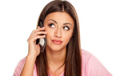 Tatmin olmamış genç bir kadın beyaz arka planda akıllı telefonuyla konuşuyor.