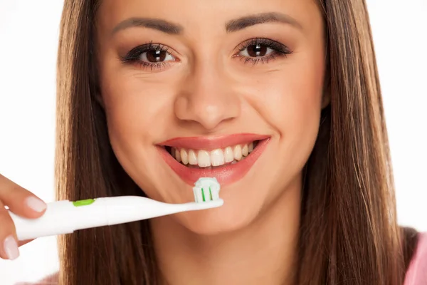 Молода Жінка Чистить Зуби Електричною Зубною Щіткою Білому Тлі — стокове фото