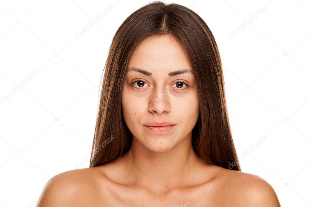 Portrait of young beautiful woman with no makeup on white background