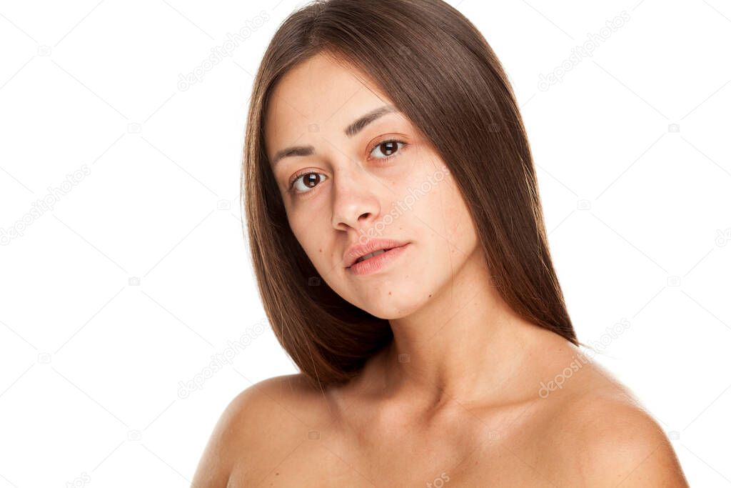 Portrait of young beautiful woman with no makeup on white background