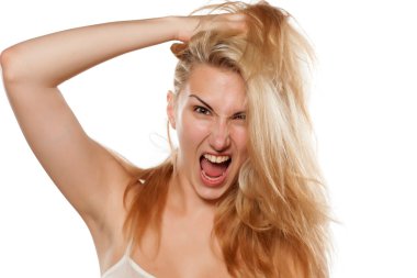 Çılgın kadın dağınık saçlarını çekiyor.