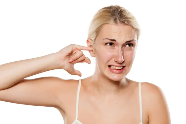 Młoda Blondynka Pchając Palec Uchu Powodu Swędzenia — Zdjęcie stockowe