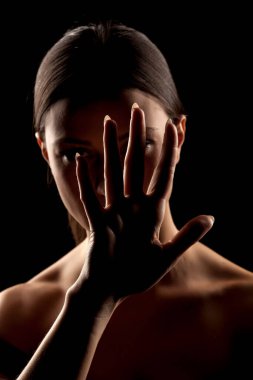 Kadının siluet portresi elleriyle durduğunu gösteriyor.