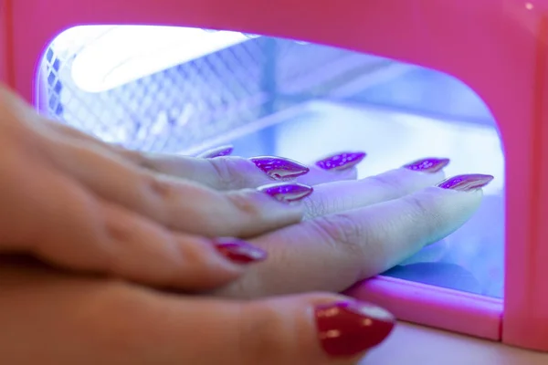 Женщина Вытирает Лак Ногтей Ультрафиолетовой Лампой — стоковое фото
