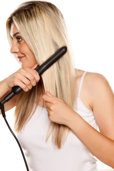 Smiling Young Woman Ironing Her Hair Hair Iron White Backgrund — Stock Photo, Image